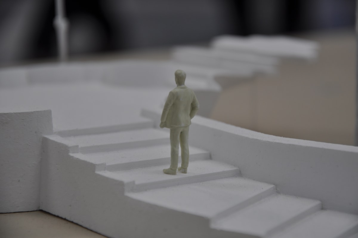 따뜻한 햇살이 비치는 홈 오피스에서 프리랜서 디자이너가 듀얼 모니터를 사용해 Maya로 정교한 3D 캐릭터 모델링을 하고 있는 모습