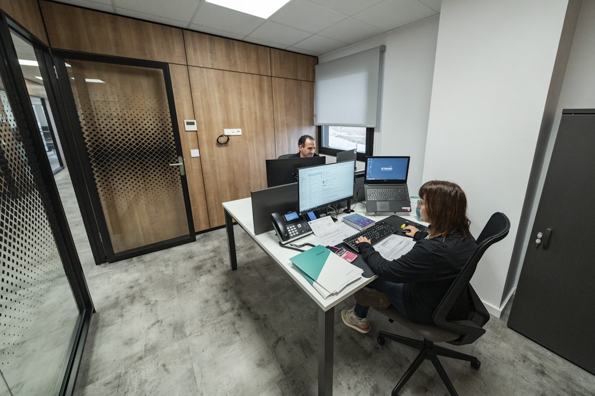 복잡한 데이터 그래프가 띄워진 듀얼 모니터 앞에서 심각하게 분석 중인 전문가의 모습