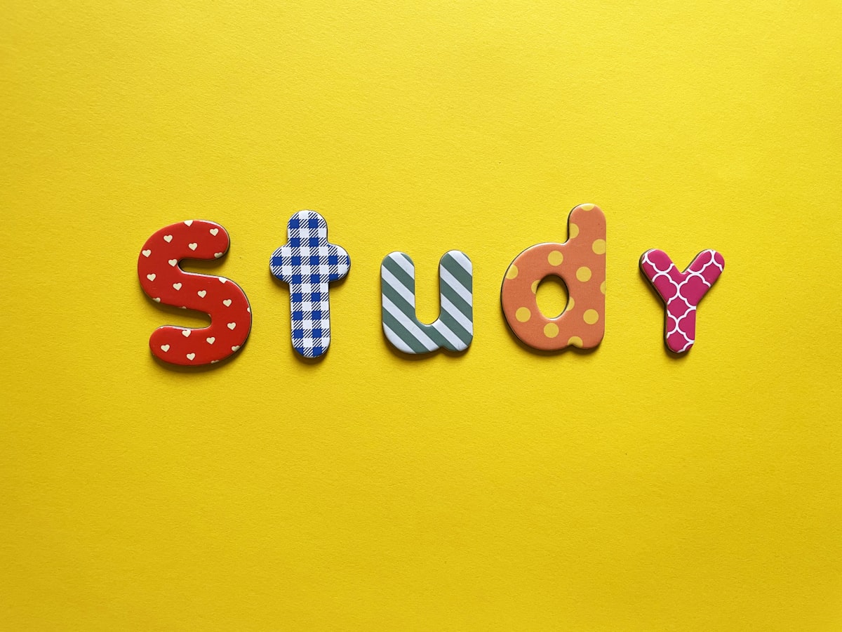 카페 창가 자리에 앉아 태블릿으로 유튜브 강의를 보며 필기하는 대학생의 모습