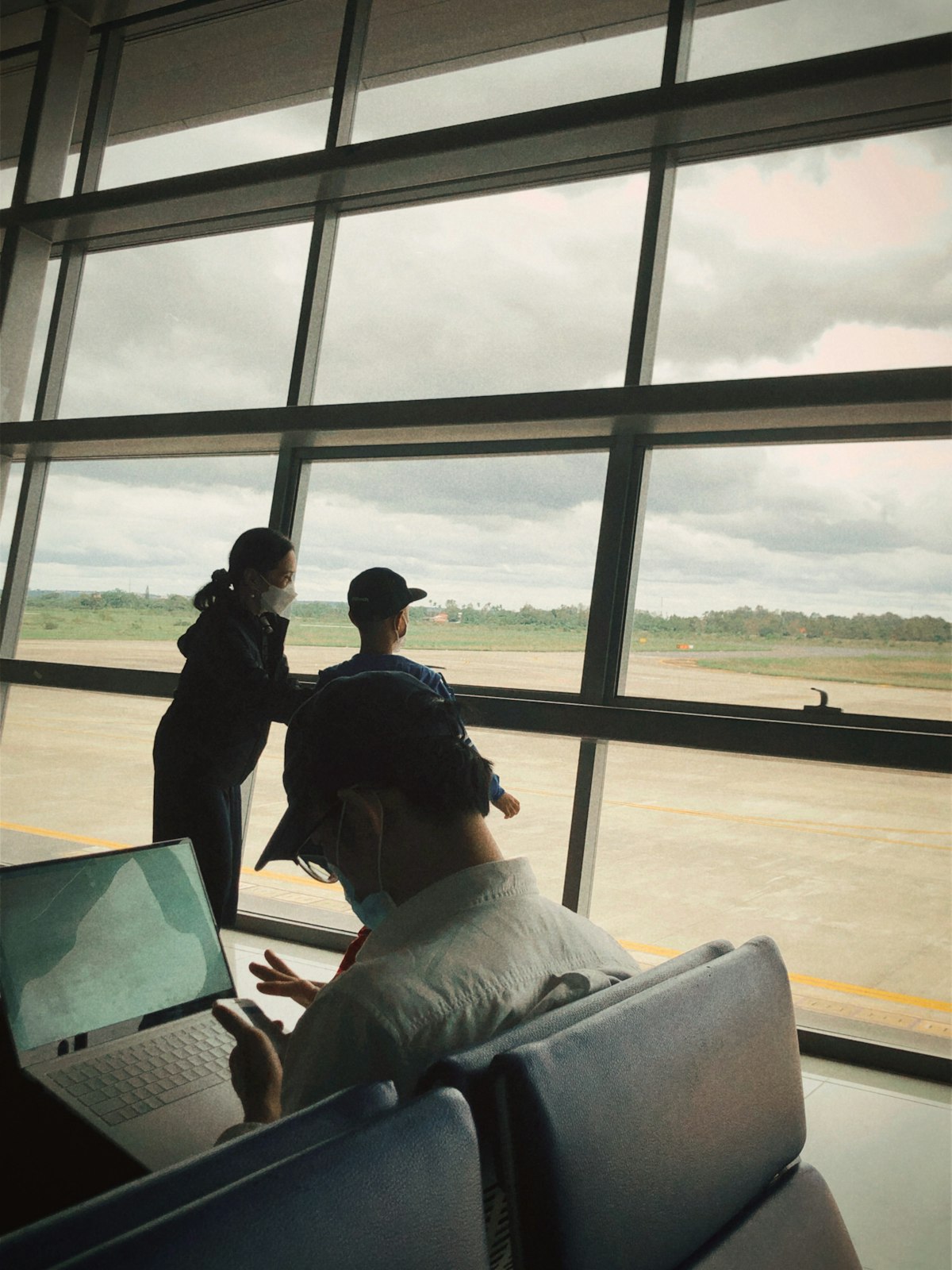 공항 라운지에서 태블릿으로 클룩 앱의 복잡한 할인 코드를 조합하며 호텔 예약을 최적화하는 여행자의 모습