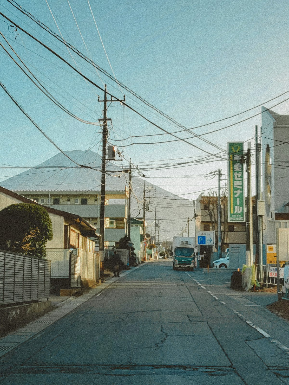 일본의 좁은 골목길에서 렌터카를 조심스럽게 운전하며 사이드미러를 확인하는 운전자의 시점