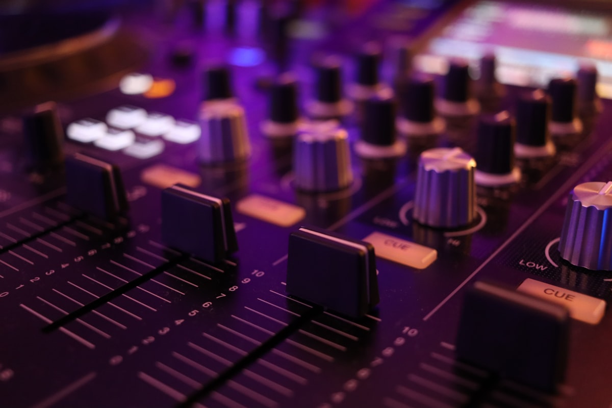 홈 레코딩 스튜디오에서 고성능 헤드폰을 착용하고 미디 컨트롤러를 조작하며 작곡에 몰두하는 아티스트의 뒷모습