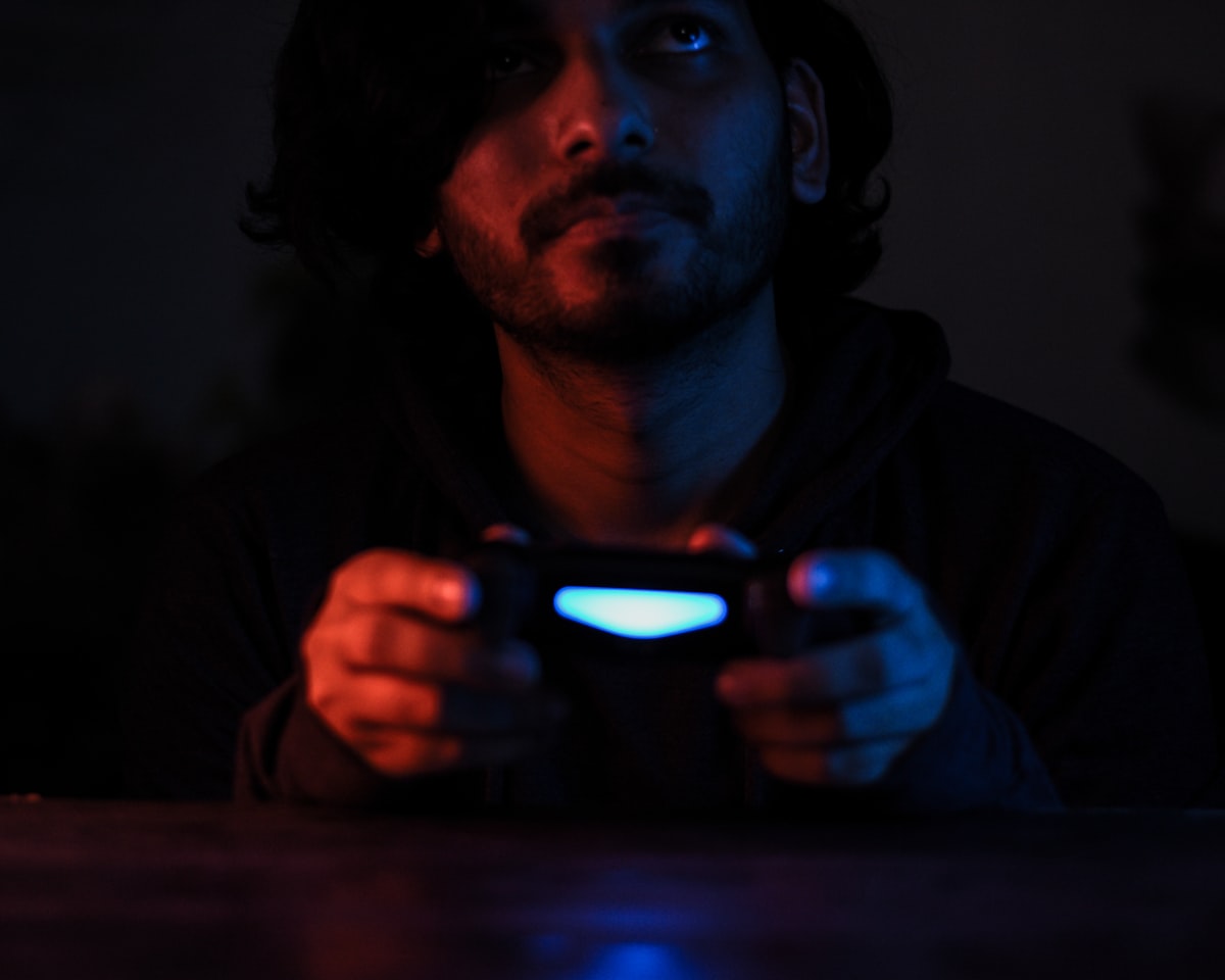 고급 사양의 게이밍 데스크탑 앞에 앉아 머리를 감싸쥐며 최적화 실패에 분노하는 게이머의 뒷모습