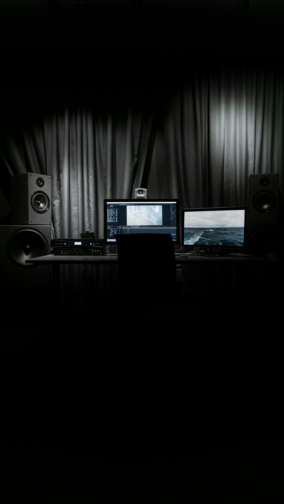 모던한 작업실에서 듀얼 모니터를 활용해 수노 AI의 파형을 분석하며 음악 작업을 하고 있는 프로듀서의 뒷모습