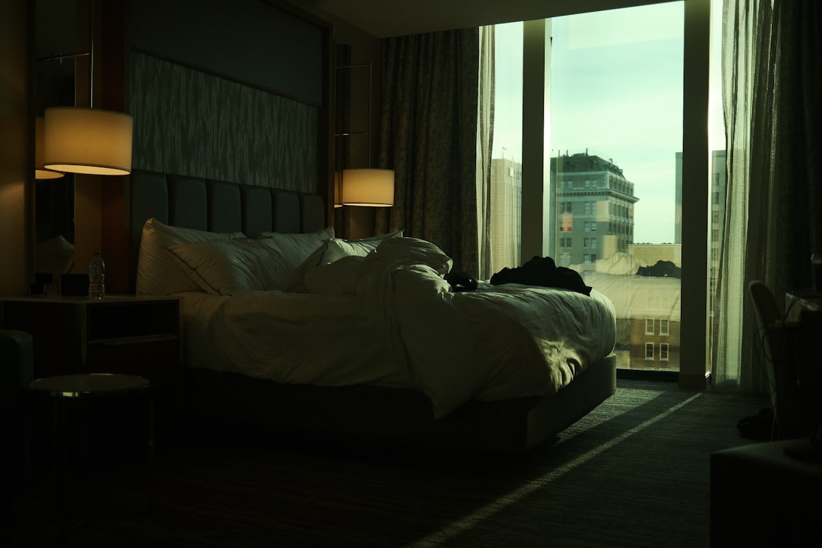 침대 위에 놓인 웰컴 기프트와 세련된 호텔 객실 내부의 아늑한 분위기